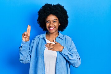 Young african american woman wearing casual clothes smiling swearing with hand on chest and fingers...