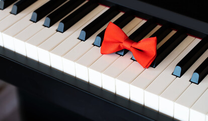Red bow tie on piano keyboard. Closeup