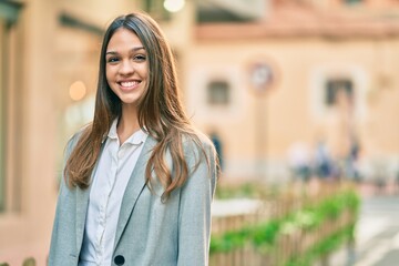 Young latin businesswoman smiling happy standing at the city.