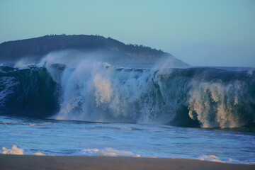 Waves breaking in the sea at Piratininga Beach, Niterói in Rio de Janeiro. I die in the background. Late summer afternoon.