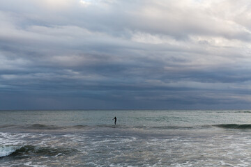 Fototapeta na wymiar Seascape of the Mediterranean sea after a storm, surfers practicing bodyboar on the waves