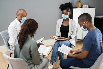 Group Of People Study Religious Book With Preacher