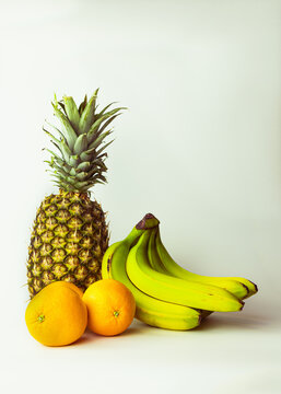 Exotic fruit. Pineapple, bananas and oranges on white background