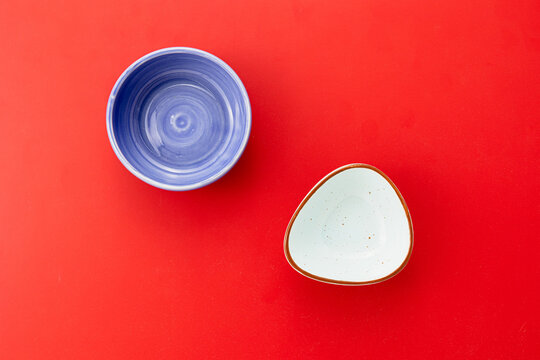 Empty food bowls on red background