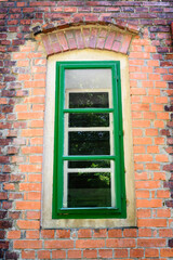Green window frame with red bricks.