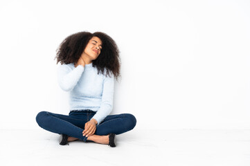 Young african american woman sitting on the floor with neckache