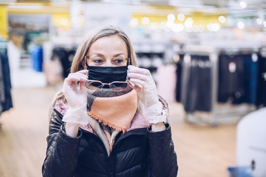 Woman with long blond hair tries on sunglasses in the store.