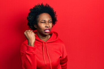 Fototapeta na wymiar Young african american woman wearing casual sweatshirt angry and mad raising fist frustrated and furious while shouting with anger. rage and aggressive concept.