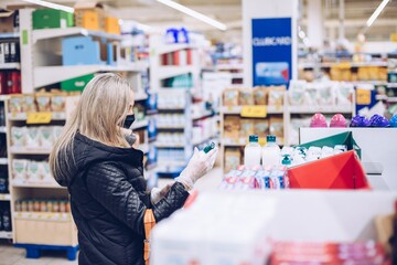 Woman shopping during coronavirus pandemic. Product selection.
