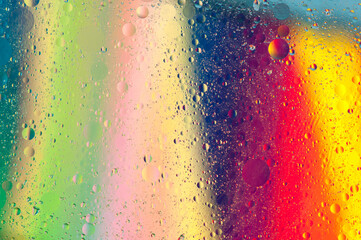 Abstract iridescent blurred background with water and oil drops on the surface