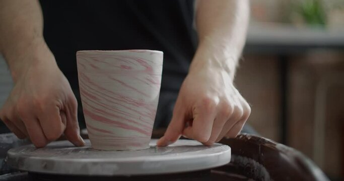 Close up view: potter separates the molded nerikomi pot from the potter's wheel, pottery workshop, ceramics craftsmanship, 4k 60p Prores HQ 10 bit