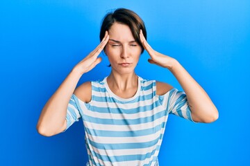 Young brunette woman with short hair wearing casual striped t-shirt suffering from headache desperate and stressed because pain and migraine. hands on head.