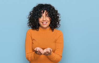 Young hispanic woman wearing casual clothes smiling with hands palms together receiving or giving gesture. hold and protection
