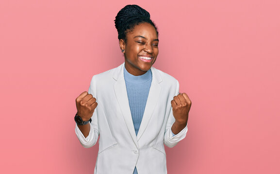 Young african american woman wearing business clothes very happy and excited doing winner gesture with arms raised, smiling and screaming for success. celebration concept.