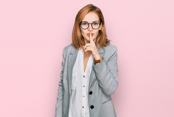 Young caucasian woman wearing business style and glasses asking to be quiet with finger on lips. silence and secret concept. - obrazy, fototapety, plakaty