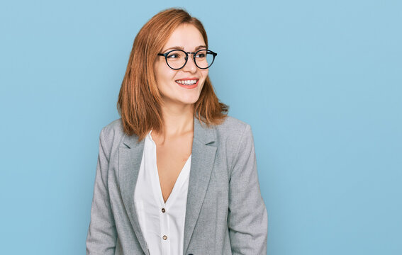 Young caucasian woman wearing business style and glasses looking away to side with smile on face, natural expression. laughing confident.