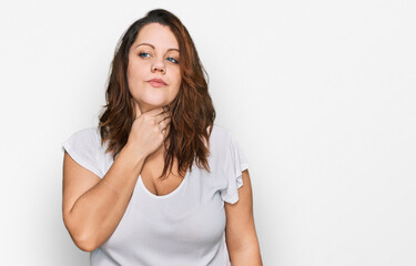 Fototapeta premium Young plus size woman wearing casual white t shirt touching painful neck, sore throat for flu, clod and infection
