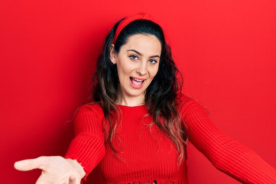 Young hispanic woman wearing casual clothes smiling cheerful offering hands giving assistance and acceptance.