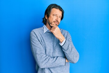 Middle age handsome man wearing casual clothes smiling looking confident at the camera with crossed arms and hand on chin. thinking positive.