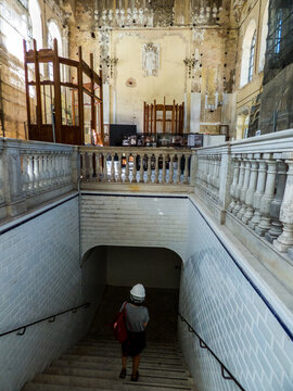 Una persona de espaldas y con casco desciende hacia el paso subterr&aacute;neo que comunicaba la sala principal de la estaci&oacute;n de ferrocarril de Canfranc, Espa&ntilde;a, con la zona de los andenes