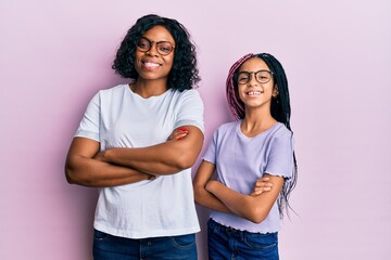 Beautiful african american mother and daughter wearing casual clothes and glasses happy face...