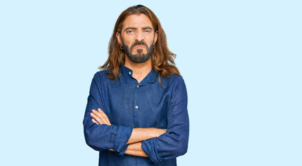 Attractive man with long hair and beard wearing casual clothes skeptic and nervous, disapproving...