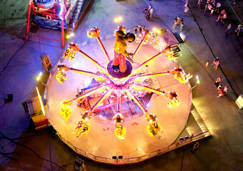 moving fairground attraction seen from above with people around it
