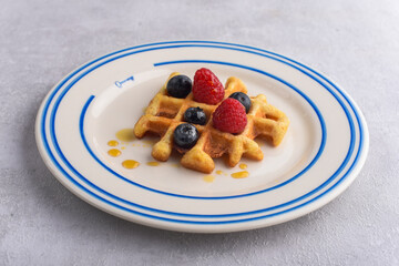 Belgian waffle served by berries