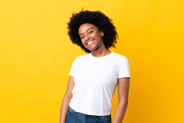 Young African American woman isolated on yellow background laughing