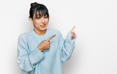 Young hispanic woman wearing casual clothes pointing aside worried and nervous with both hands, concerned and surprised expression