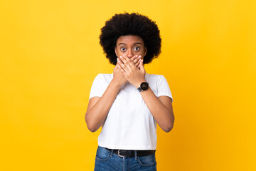 Fototapeta na wymiar Young African American woman isolated on yellow background covering mouth with hands
