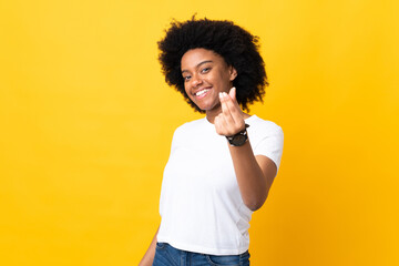 Young African American woman isolated on yellow background making money gesture