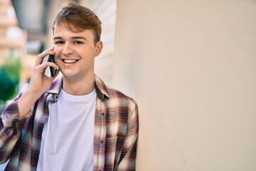 Young caucasian man smiling happy talking on the smartphone at the city.