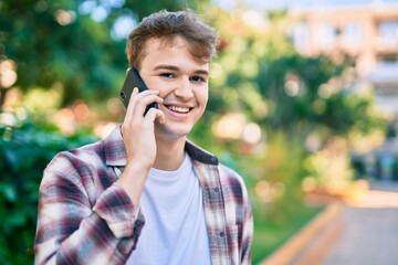 Young caucasian man smiling happy talking on the smartphone at the city.