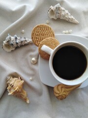 a cup of coffee cookies pearl and shell
