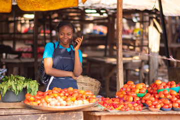 african woman with a phone in a market