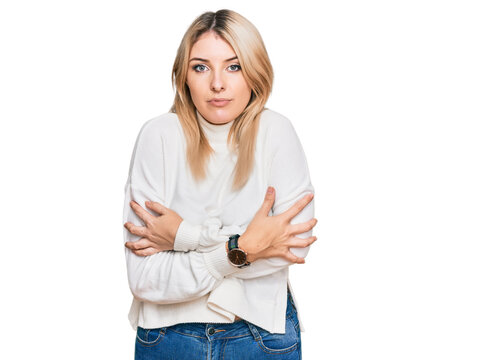 Young caucasian woman wearing casual winter sweater shaking and freezing for winter cold with sad and shock expression on face