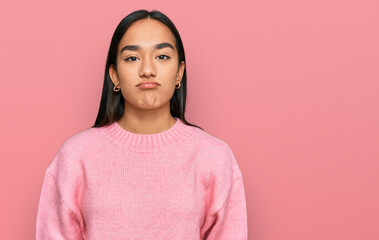 Young asian woman wearing casual winter sweater looking sleepy and tired, exhausted for fatigue and hangover, lazy eyes in the morning.