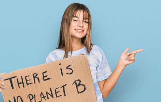 Teenager caucasian girl holding there is no planet b banner smiling happy pointing with hand and finger to the side