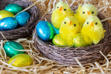 Pâques. Décoration avec nids et petits poussins synthétiques et œufs de Pâques, sur de la...