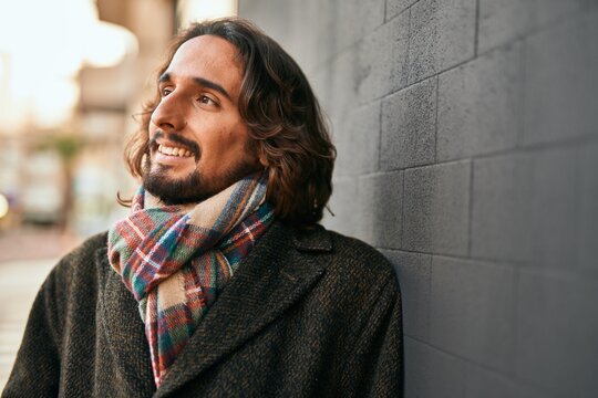 Young hispanic man smiling happy standing at the city.