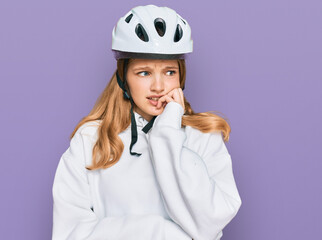 Beautiful young caucasian girl wearing bike helmet looking stressed and nervous with hands on mouth biting nails. anxiety problem.
