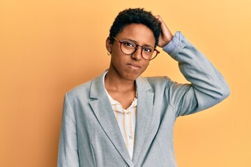 Young african american girl wearing business jacket and glasses confuse and wonder about question. uncertain with doubt, thinking with hand on head. pensive concept.