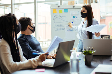 Business team wearing protective masks while meeting in the office during the COVID-19 epidemic
