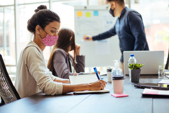 Business team wearing protective masks while meeting in the office during the COVID-19 epidemic