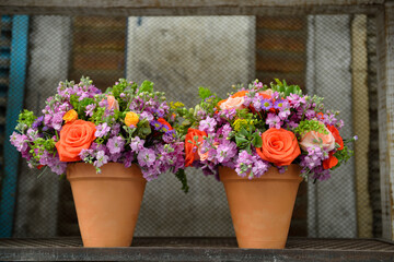 Fototapeta na wymiar A couple mud vase with flowers on a wood table
