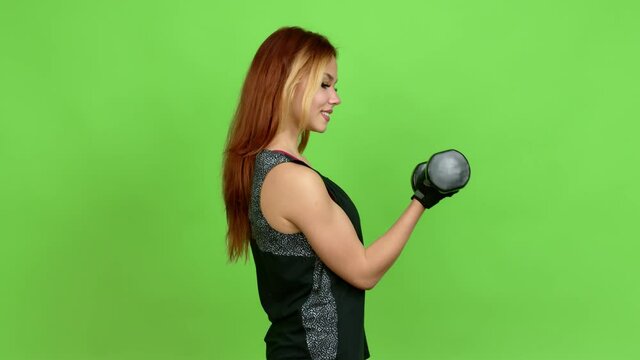 Young blonde teenager girl doing sport and doing weightlifting over isolated background. Green screen chroma key