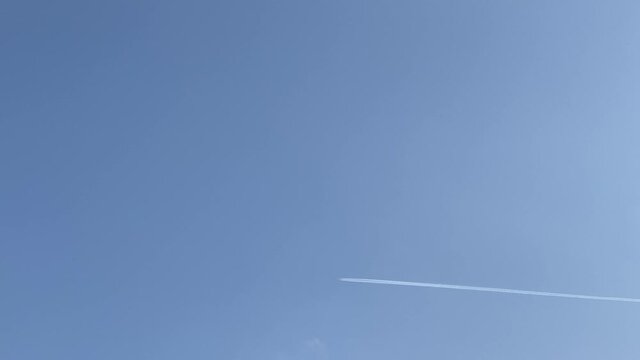 青空の下のほうを右から左に横切る飛行機雲