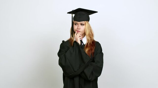 Young blonde teenager girl with graduation gown having doubts and questioning an idea over isolated background