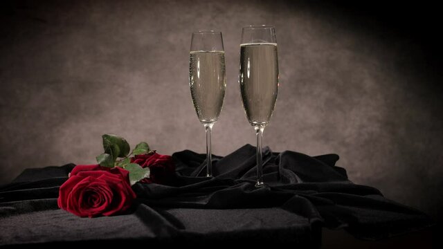 Sparkling wine and red roses in close-up - studio photography